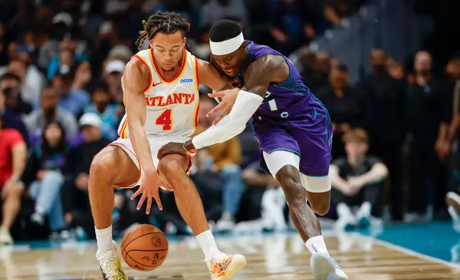 Atlanta Hawks guard Kingston Flemings (4) battles Charlotte Hornets guard Dennis Schroder, right, for the ball during the first half of an NBA basketball game in Charlotte, N.C., Friday, Oct. 23, 2026. (AP Photo/Nell Redmond)