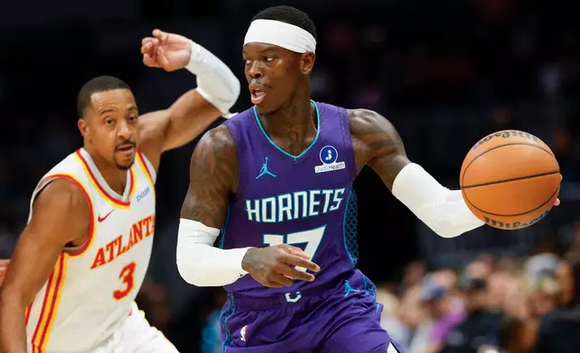 Charlotte Hornets guard Dennis Schroder, right, moves the ball against Atlanta Hawks guard CJ McCollum, left, during the first half of an NBA basketball game in Charlotte, N.C., Friday, Oct. 23, 2026. (AP Photo/Nell Redmond)