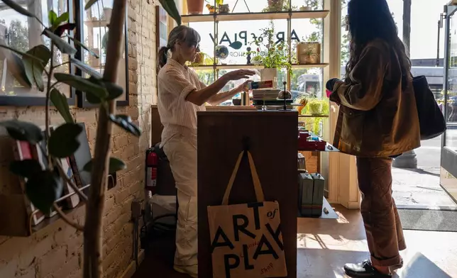 A customer purchases items at Art of Play, Tuesday, Oct. 13, 2026, in the Brooklyn borough of New York. (AP Photo/Yuki Iwamura)