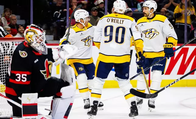Nashville Predators' Jonathan Marchessault, second from left, celebrates his goal with Ryan O'Reilly (90) and Filip Forsberg (9) during the first period of an NHL hockey game against the Ottawa Senators in Ottawa, Ontario, Saturday, Oct. 10, 2026. (Keito Newman/The Canadian Press via AP)