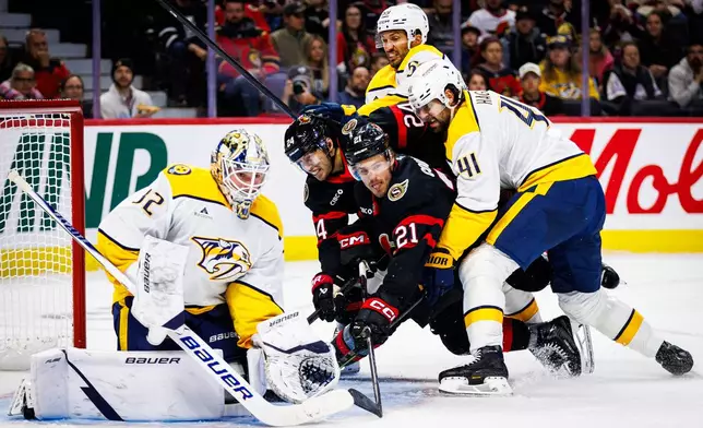 Ottawa Senators' Dylan Cozens (24) and Nick Cousins (21) battle against Nashville Predators' Roman Josi (top) and Nicolas Hague (41) in front of goaltender Matt Murray (32) during second period of an NHL hockey game in Ottawa, Ontario, Saturday, Oct. 10, 2026. (Keito Newman/The Canadian Press via AP)