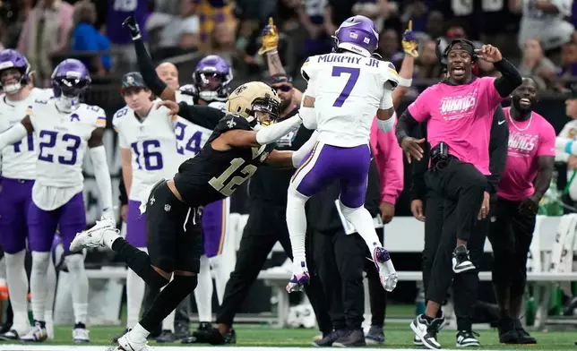 Minnesota Vikings cornerback Byron Murphy Jr. (7) intercepts a pass intended for New Orleans Saints wide receiver Chris Olave (12) during the second half of an NFL football game in New Orleans, Sunday, Oct. 11, 2026. (AP Photo/Gerald Herbert)