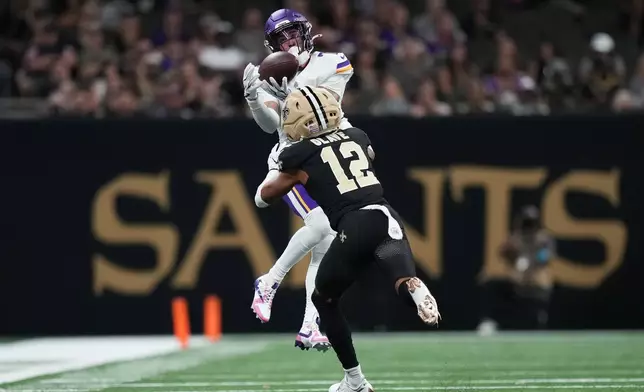Minnesota Vikings cornerback Byron Murphy Jr., top, intercepts a pass intended for New Orleans Saints wide receiver Chris Olave (12) during the second half of an NFL football game in New Orleans, Sunday, Oct. 11, 2026. (AP Photo/Matthew Hinton)