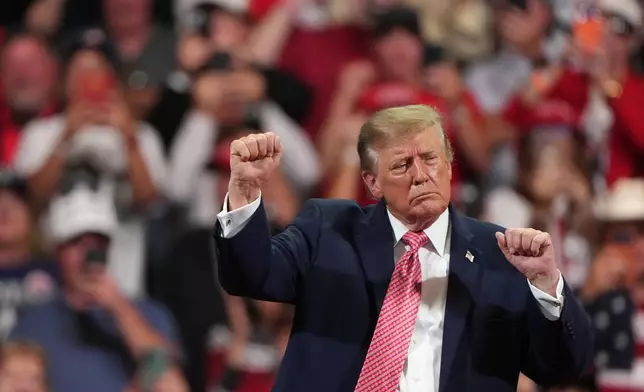 President Donald Trump dances at a campaign rally at Heartland Credit Union Arena, Monday, Oct. 19, 2026, in Park City, Kan. (AP Photo/Charlie Riedel)