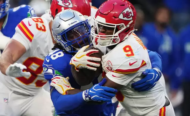 Kansas City Chiefs running back Kenneth Walker III (9) is stopped with the ball by Seattle Seahawks linebacker Tyrice Knight (48) during the first half of an NFL football game in Seattle, Sunday, Oct. 25, 2026. (AP Photo/Lindsey Wasson)