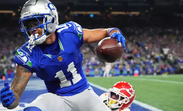 Seattle Seahawks wide receiver Jaxon Smith-Njigba (11) reacts after a catch for a touchdown in front of Kansas City Chiefs cornerback Mansoor Delane (5) during the first half of an NFL football game in Seattle, Sunday, Oct. 25, 2026. (AP Photo/Lindsey Wasson)