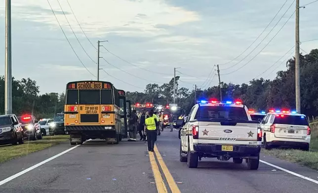 In this photo provided by the Polk County Sheriff's Office, emergency personnel respond to an accident involving a school bus in Winter Haven, Fla., on Monday, Oct. 5, 2026. (Polk County Sheriff's Office via AP)