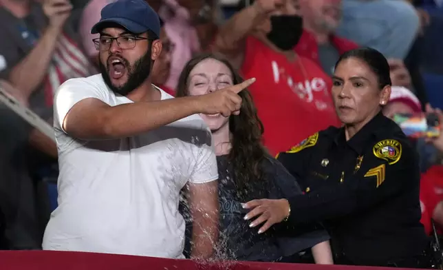 Police remove protesters as President Donald Trump speaks at a campaign rally at the Freeman Coliseum in San Antonio, Wednesday, Oct. 7, 2026. (AP Photo/Eric Gay)