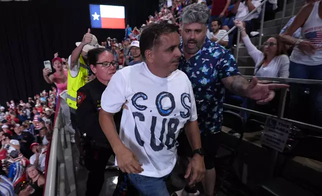Police remove a protester as President Donald Trump speaks at a campaign rally at the Freeman Coliseum in San Antonio, Wednesday, Oct. 7, 2026. (AP Photo/Alex Brandon)