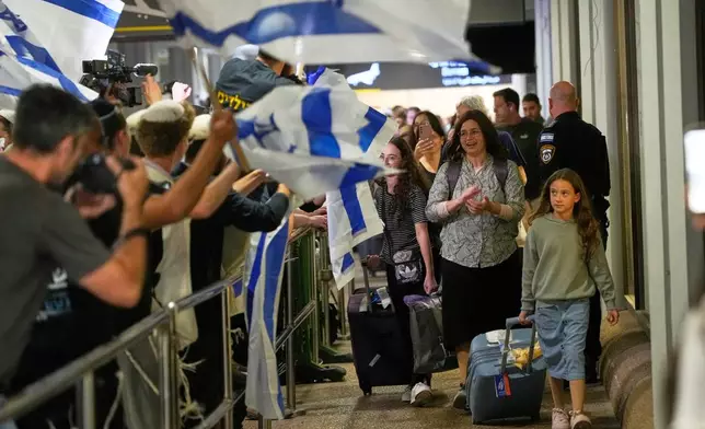 Israeli passengers who had been aboard a FlyDubai aircraft that made an emergency landing in Saudi Arabia are welcomed at the arrivals gate at Ben Gurion International Airport near Tel Aviv, Israel, Wednesday, Sept. 30, 2026. (AP Photo/Ohad Zwigenberg)