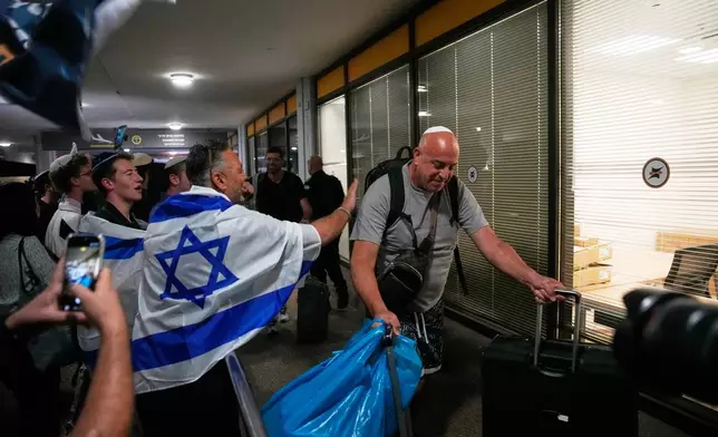 Israeli passengers who had been aboard a FlyDubai aircraft that made an emergency landing in Saudi Arabia are welcomed at the arrivals gate at Ben Gurion International Airport near Tel Aviv, Israel, Wednesday, Sept. 30, 2026. (AP Photo/Ohad Zwigenberg)