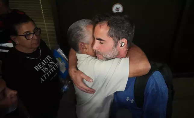 Israeli passenger Asaf Rajuan, right, who experienced an emergency landing in Saudi Arabia, during a flight on a FlyDubai plane, hugs another passenger from the same flight as they arrive at Ben Gurion International Airport, near Tel Aviv, Israel, Wednesday, Sept. 30, 2026. (AP Photo/Ariel Schalit)