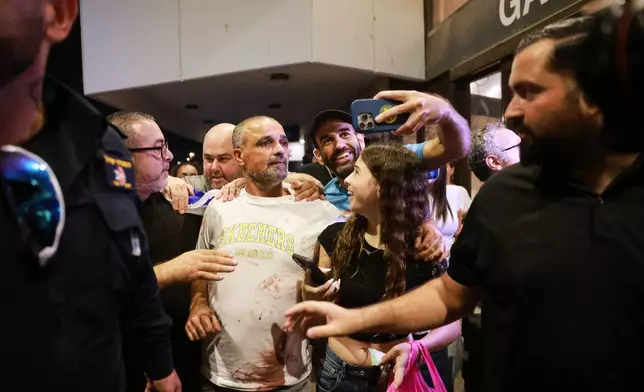Israeli passenger Yaniv Hayoun, with blood stains on his shirt, who was aboard a Flydubai aircraft that made an emergency landing in Saudi Arabia, is welcomed at the arrivals gate at Ben Gurion International Airport near Tel Aviv, Israel, Wednesday, Sept. 30, 2026. (AP Photo/Tomer Appelbaum)