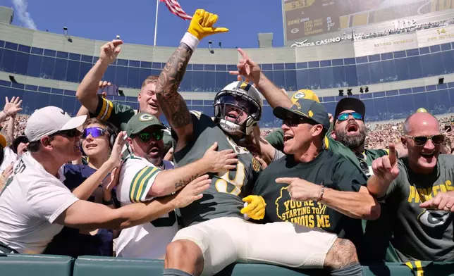 Green Bay Packers' Christian Watson celebrates with fans after catching a touchdown pass during the first half of an NFL football game against the Chicago Bears in Green Bay, Wis., Sunday, Oct. 11, 2026. (AP Photo/Mike Roemer)