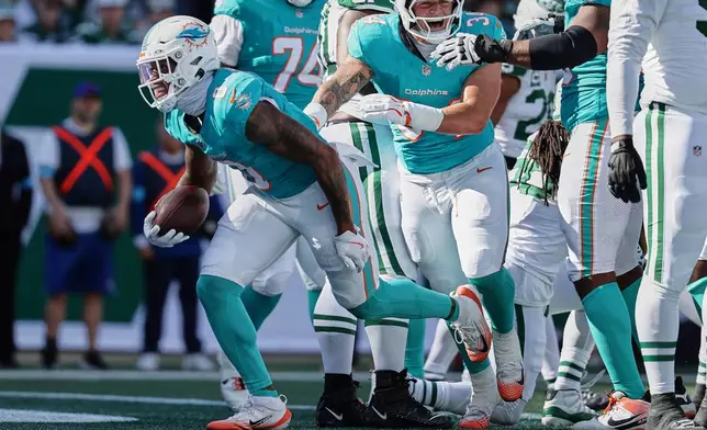 Miami Dolphins running back Ollie Gordon II, left, carries in for a touchdown in the first half of an NFL football game against the New York Jets in East Rutherford, N.J., Sunday, Oct. 25, 2026. (AP Photo/Adam Hunger)