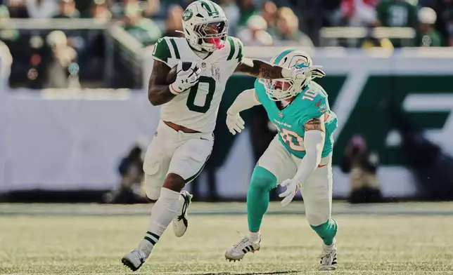 New York Jets running back Braelon Allen (0) is pursued by Miami Dolphins linebacker Jacob Rodriguez (10) in the second half of an NFL football game in East Rutherford, N.J., Sunday, Oct. 25, 2026. (AP Photo/Adam Hunger)