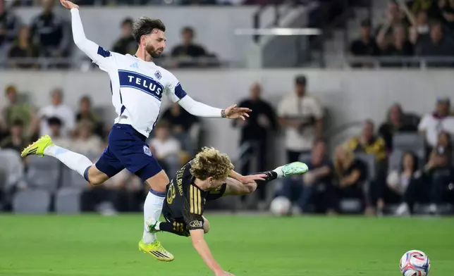 Vancouver Whitecaps FC defender Tristan Blackmon, left, commits a foul on Los Angeles Football Club forward Jacob Shaffelburg during the first half of an MLS soccer match in Los Angeles, Saturday, Oct. 10, 2026. (AP Photo/Kyusung Gong)