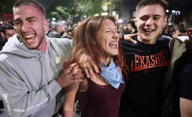 Youngsters celebrate after Aleksandar Vucic, leader of the right-wing Serbian Progressive Party (SNS) conceded defeat in the parliamentary election in Belgrade, Serbia, Sunday, Oct. 25, 2026. (AP Photo/Armin Durgut)