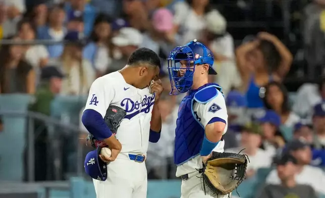 Los Angeles Dodgers catcher Will Smith, right, talks with pitcher Edwin Diaz after Diaz gave up a home run during the ninth inning of Game 4 of baseball's National League Championship Series between the Milwaukee Brewers and the Los Angeles Dodgers, Thursday, Oct. 15, 2026, in Los Angeles. (AP Photo/Mark J. Terrill)