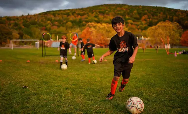 Autumn-colored foliage in Berkshire County serves as backdrop where Krish Panwala practices soccer with his Wildcat teammates, Monday, Oct. 12, 2026, in Lee, Mass. (AP Photo/Robert F. Bukaty)
