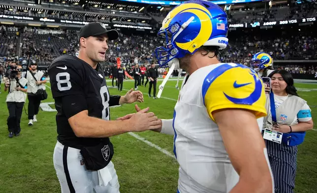 Las Vegas Raiders quarterback Kirk Cousins (8) talks to Los Angeles Rams quarterback Matthew Stafford following an NFL football game Sunday, Oct. 25, 2026, in Las Vegas. (AP Photo/John Locher)
