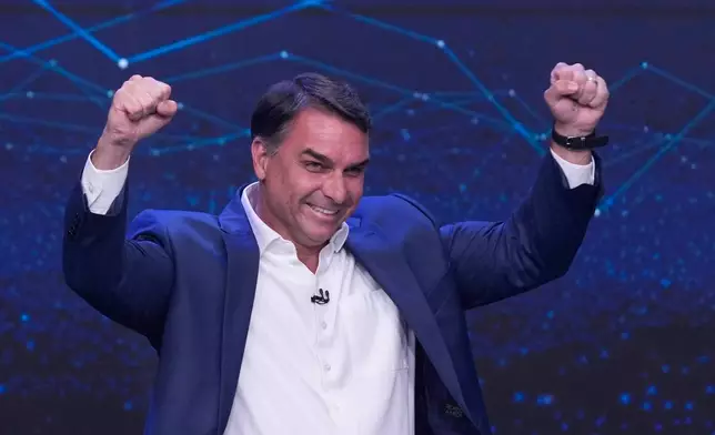 Opposition presidential candidate Sen. Flavio Bolsonaro raises his fists in celebration at the end of a televised presidential debate one week before the presidential runoff election in Sao Paulo, Brazil, Sunday, Oct. 18, 2026. (AP Photo/Andre Penner)