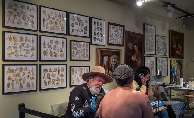 Tattoo artist Henk Schiffmacher tattoos one of Dutch artist Rembrandt's sketches onto the arm of a client in a studio in the Rembrandt House Museum in Amsterdam, Tuesday, Oct. 27, 2026. (AP Photo/Patrick Post)