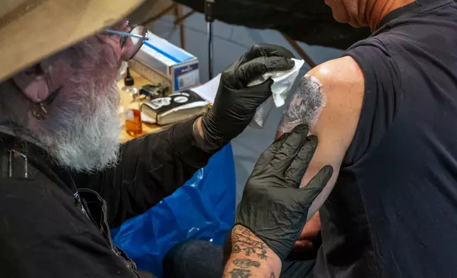 Tattoo artist Henk Schiffmacher tattoos a self-portrait of Dutch artist Rembrandt onto the arm of Associated Press journalist Mike Corder in a studio in the Rembrandt House Museum in Amsterdam, Tuesday, Oct. 27, 2026. (AP Photo/Patrick Post)