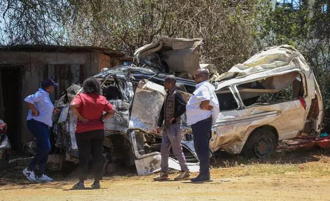 People view the wreckage of a 14-seater minibus that was involved in an accident killing all the passengers, in the Salama area, Makueni County, Eastern Kenya, Saturday, Oct. 3, 2026. (AP Photo/Andrew Kasuku)