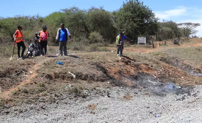 People gather at the scene where a 14-seater minibus was involved in an accident killing all the passengers, in the Salama area, Makueni County, Eastern Kenya, Saturday, Oct. 3, 2026. (AP Photo/Andrew Kasuku)
