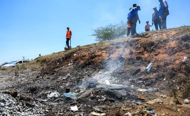 People gather at the scene where a 14-seater mini bus was involved in an accident killing all the passengers, in the Salama area, Makueni County, Eastern Kenya, Saturday, Oct. 3, 2026. (AP Photo/Andrew Kasuku)