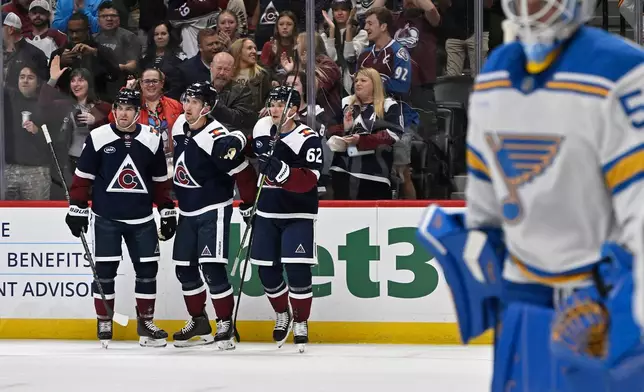 From left, Colorado Avalanche defenseman Devon Toews (7) celebrates a goal by teammate Martin Necas (88) with left wing Artturi Lehkonen (62) as St. Louis Blues goaltender Jordan Binnington (50) skates away during the first period of an NHL hockey game Saturday, Oct. 3, 2026, in Denver. (AP Photo/RJ Sangosti)