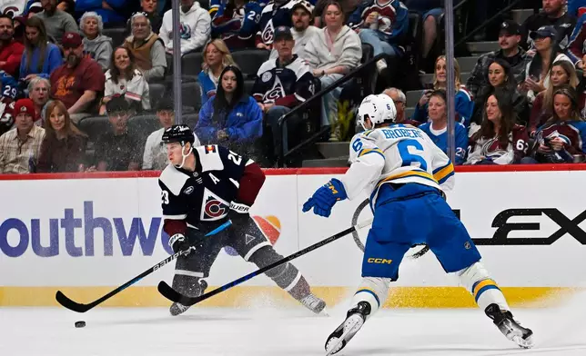 Colorado Avalanche center Nathan MacKinnon, left, moves the puck downice against St. Louis Blues defenseman Philip Broberg (6) in the first period of an NHL hockey game, Saturday, Oct. 3, 2026, in Denver. (AP Photo/RJ Sangosti)