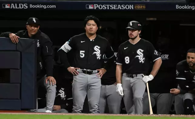 Chicago White Sox first baseman Munetaka Murakami (5) and catcher Kyle Teel (8) watch from the dugout during the eighth inning of Game 5 of baseball's American League Division Series against the Cleveland Guardians, Saturday, Oct. 10, 2026, in Cleveland. (AP Photo/Phil Long)