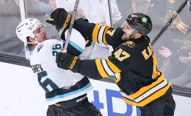 Boston Bruins' Mark Kastelic, right, battles Utah Mammoth's Dmitri Simashev (26) during the third period of an NHL hockey game, Thursday, Oct. 8, 2026, in Boston. (AP Photo/Charles Krupa)