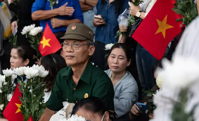 People watch as 731 sets of martyrs' remains found at Le Thi Rieng Cultural Park are transferred for burial at Ho Chi Minh City Martyrs' Cemetery Wednesday, Oct. 14, 2026, in Ho Chi Minh City, Vietnam. (AP Photo/Thanh Hue)