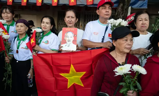 People watch as 731 sets of martyrs' remains found at Le Thi Rieng Cultural Park are transferred for burial at Ho Chi Minh City Martyrs' Cemetery Wednesday, Oct. 14, 2026 in Ho Chi Minh City, Vietnam. (AP Photo/Thanh Hue)