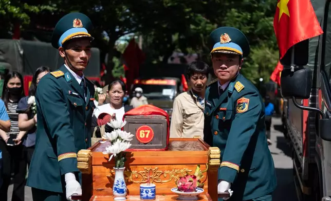 Military personnel carry the remains of 731 martyrs' remains found at Le Thi Rieng Cultural Park for burial at Ho Chi Minh City Martyrs' Cemetery Wednesday, Oct. 14, 2026, in Ho Chi Minh City, Vietnam. (AP Photo/Thanh Hue)