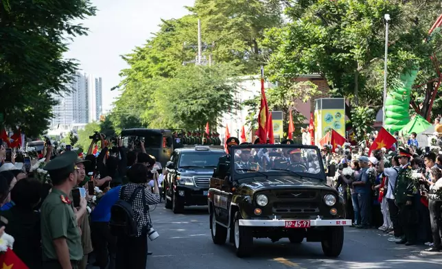 People watch as 731 sets of martyrs' remains found at Le Thi Rieng Cultural Park are transferred for burial at Ho Chi Minh City Martyrs' Cemetery Wednesday, Oct. 14, 2026, in Ho Chi Minh City, Vietnam. (AP Photo/Thanh Hue)