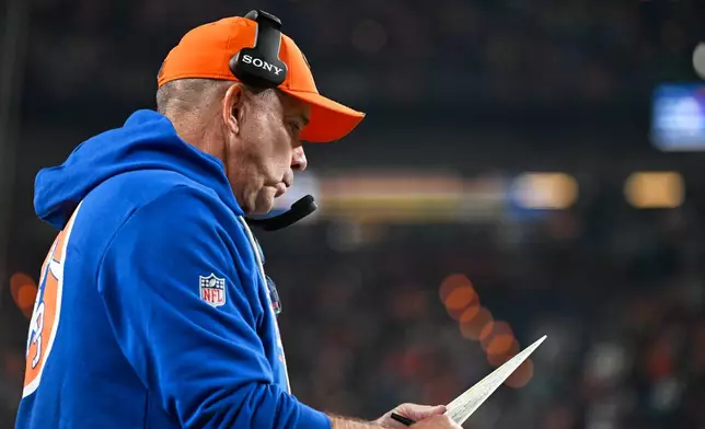 Denver Broncos head coach Sean Payton looks at a play sheet during the second half of an NFL football game against the Seattle Seahawks in Denver, Thursday, Oct. 15, 2026. (AP Photo/Geneva Heffernan)