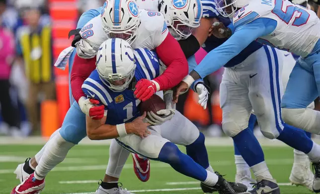 Tennessee Titans defensive tackle Jeffery Simmons (98) sacks Indianapolis Colts quarterback Daniel Jones, below, during the second half of an NFL football game Sunday, Oct. 18, 2026, in Indianapolis. (AP Photo/Jeff Roberson)
