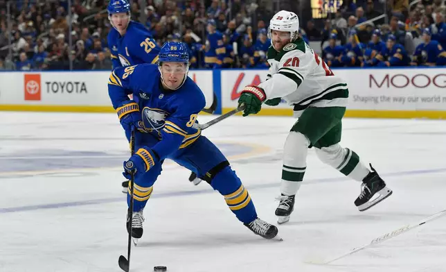 Buffalo Sabres center Noah Ostlund, left, is defended by Minnesota Wild left wing Blake Coleman during the first period of an NHL hockey game Tuesday, Oct. 6, 2026, in Buffalo, N.Y. (AP Photo/Adrian Kraus)