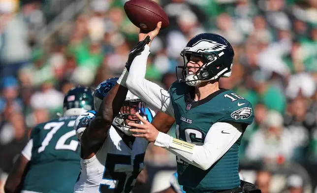 Philadelphia Eagles quarterback Tanner McKee, right, attempts a pass under pressure from Carolina Panthers inside linebacker Bobby Okereke (58) during the second half of an NFL football game in Philadelphia, Sunday, Oct. 18, 2026. (AP Photo/Matt Rourke)