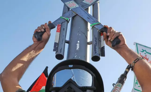 A Houthi supporter wearing a military uniform holds a mock missile during a rally in support of the group, in Sanaa, Yemen, Friday, Oct. 9, 2026. (AP Photo/Osamah Abdulrahman)