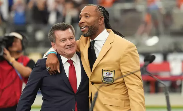 Former Arizona Cardinals wide receiver Larry Fitzgerald hugs owner Michael J. Bidwill during his Ring of Honor ceremony where his number was retired at halftime of an NFL football game between the Arizona Cardinals and the Denver Broncos in Glendale, Ariz., Sunday, Oct. 25, 2026. (AP Photo/Ross D. Franklin)