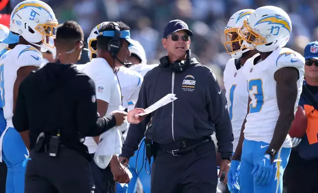 Los Angeles Chargers head coach Jim Harbaugh, center, reacts on the sideline during the first half of an NFL football game against the Seattle Seahawks, Sunday, Oct. 4, 2026, in Seattle. (AP Photo/Kevin Ng)