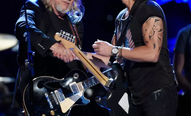 FILE - John Anderson, left, and Keith Urban shake hands at "ACM Presents: Superstar Duets" in Arlington, Texas, on April 18, 2015. (Photo by Chris Pizzello/Invision/AP, File)