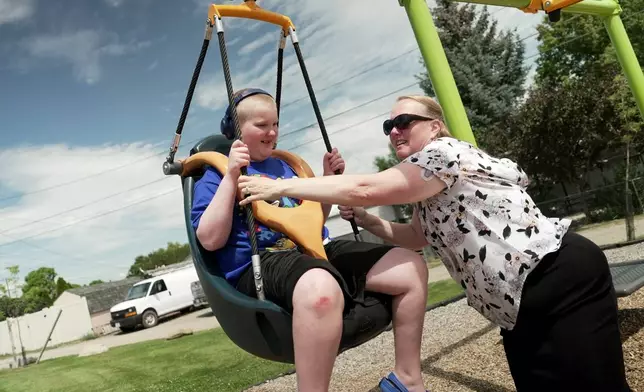 William Walter, 11, is pushed on a zipline style swing by his mother, Katherine, in Helena, Mont., July 15, 2026. (AP Photo/Shelby Lum)