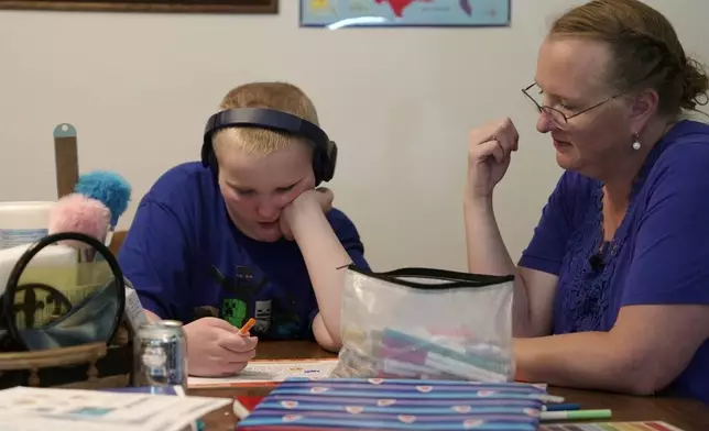 William Walter, 11, and his mother, Katherine, work during homeschooling hours in their home in White Sulphur Springs, Mont., July 16, 2026. (AP Photo/Shelby Lum)