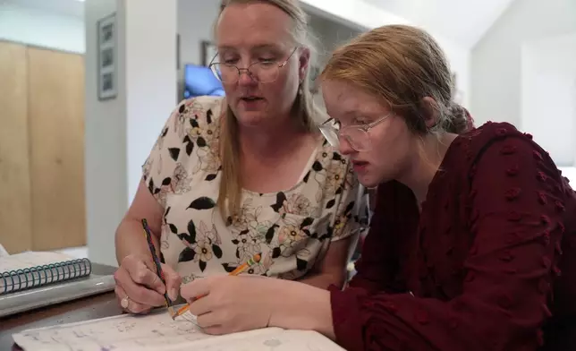 Ella Walter, 11, works with her mom, Katherine, on schoolwork at home in White Sulphur Springs, Mont., July 15, 2026. (AP Photo/Shelby Lum)